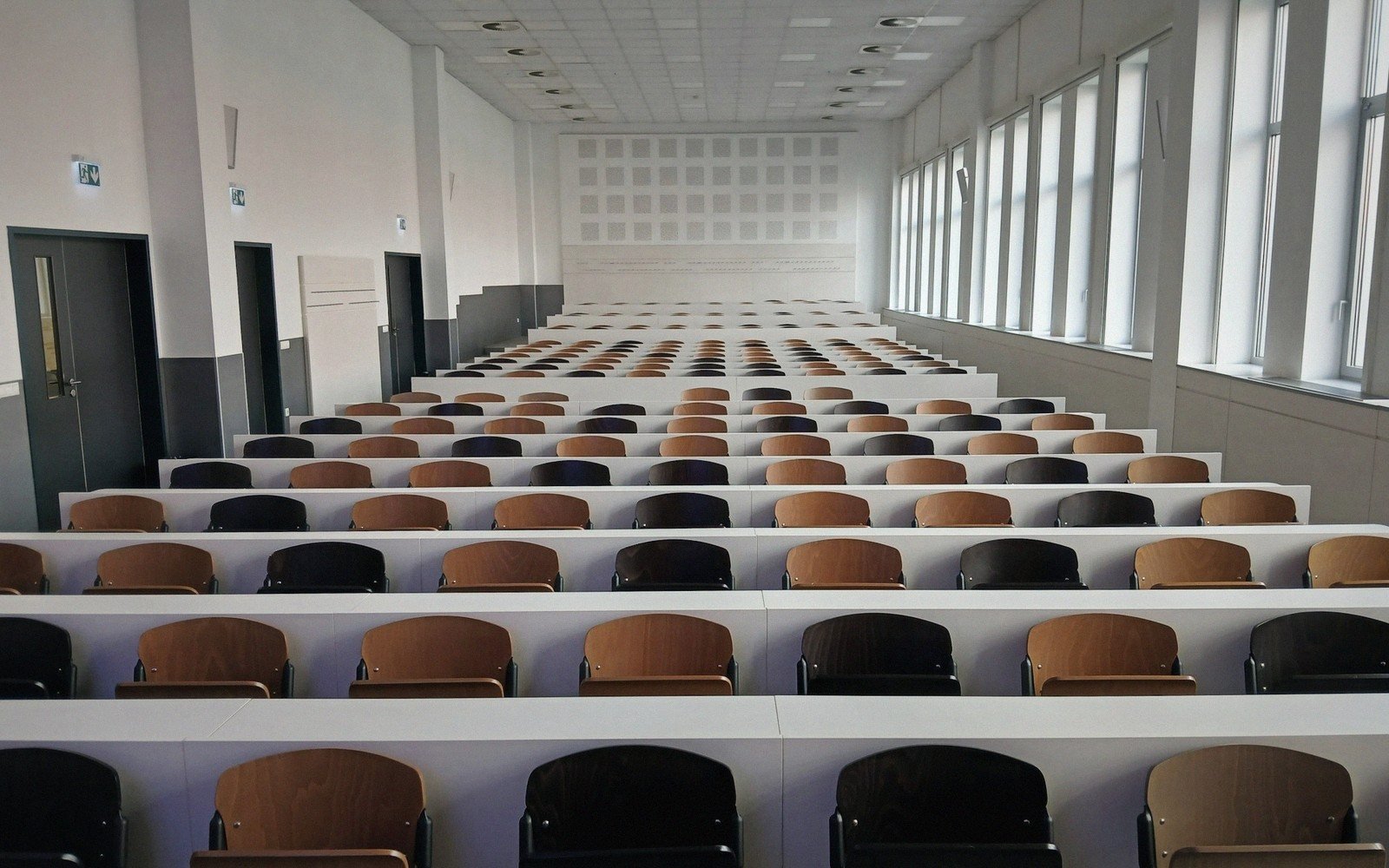 Rows of empty seats fill a long, narrow university lecture hall